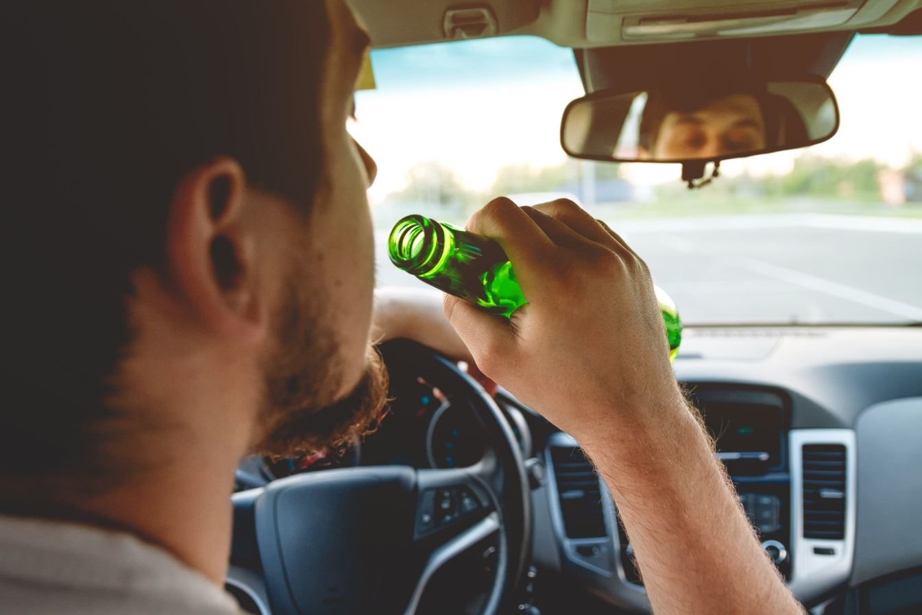 Man drinking beer and driving